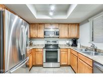 Efficient kitchen with stainless steel appliances, light wood cabinets, and a drop-in sink at 9990 N Scottsdale Rd # 2042, Paradise Valley, AZ 85253