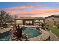 A stunning backyard oasis showcasing a private pool, spa, built-in BBQ, and desert landscaping at 12381 S 182Nd Dr, Goodyear, AZ 85338