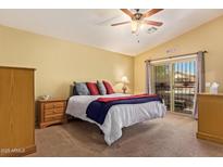 Bright bedroom with a ceiling fan, sliding glass door, and a comfortable bed with colorful pillows and blankets at 174 W Del Rio St, Gilbert, AZ 85233