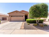 Charming single-story home featuring a desert landscape, a two-car garage, and a welcoming entrance at 18896 N Lariat Rd, Maricopa, AZ 85138