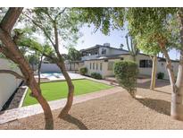 Expansive backyard with a pool, lush landscaping, and a well-maintained lawn at 3371 W Grandview Rd, Phoenix, AZ 85053