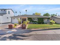 Charming single-story home with well-manicured lawn and lush greenery at 3411 E Sells Dr, Phoenix, AZ 85018