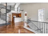 Bright living room features hardwood floors, spiral staircase, and seamless flow into the kitchen at 5729 S 21St Ter, Phoenix, AZ 85040
