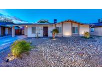 Charming single-story home with desert landscaping, solar panels, and a welcoming front entrance at 8930 W Sells Dr, Phoenix, AZ 85037
