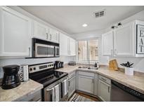 Well-lit kitchen featuring modern appliances, light countertops and white cabinets offering a clean, efficient cooking space at 10401 N 52Nd St # 210, Paradise Valley, AZ 85253