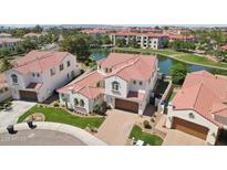 An aerial view of a two-story home showing a red tile roof near a scenic lake with a lush green landscape at 2454 W Hope Cir, Chandler, AZ 85248