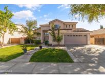 Charming two-story home with landscaped yard and a two car garage under a sunny, blue sky at 285 W Goldfinch Way, Chandler, AZ 85286