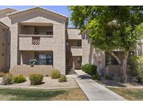 Exterior view of a tan-colored building with balconies and lush green landscaping at 29606 N Tatum Blvd # 174, Cave Creek, AZ 85331