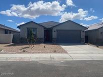 Charming single-story home featuring a gray color scheme, low-maintenance landscaping, and a spacious two-car garage at 31619 N Shady Pasture Ln, San Tan Valley, AZ 85143