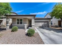Charming single-story home with a two-car garage, covered porch, and low-maintenance desert landscaping at 42180 W Cheyenne Dr, Maricopa, AZ 85138