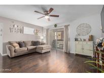 Cozy living room features hardwood floors, ceiling fan, and sliding glass doors to the patio at 4554 E Paradise Village Pkwy # 267, Phoenix, AZ 85032