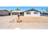 Charming single story exterior with a gravel yard, white painted brick, and attached two car garage at 8 S Cholla St, Gilbert, AZ 85233