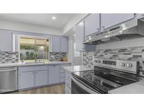Updated kitchen with stainless steel appliances, stylish tile backsplash, and quartz countertops at 9911 W Pleasant Valley Rd, Sun City, AZ 85351