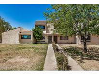 Inviting townhome featuring a well-maintained lawn, mature trees and a pathway leading to the front door at 1052 S San Jose St # 6, Mesa, AZ 85202