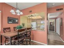 Cozy dining area featuring a wooden table, ornate chairs, and an open view into the kitchen at 145 N 74Th St # 240, Mesa, AZ 85207