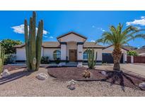 Charming home featuring desert landscaping, including saguaro cactus and a palm tree in the front yard at 1811 E Tierra Buena Ln, Phoenix, AZ 85022