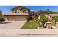 Charming two-story home featuring a lush lawn, mature palm trees, and a three-car garage, perfect for Gathering living at 1946 E Caroline Ln, Tempe, AZ 85284