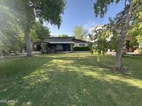 Charming single-story home featuring a lush green lawn and mature trees at 313 E 15Th St, Tempe, AZ 85281