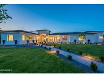Stunning single-story home with manicured front yard, stone accents, walkway lighting, and lush green lawn at 3950 E Augusta Ave, Queen Creek, AZ 85142