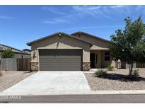 Charming single-story home featuring a two-car garage, well-maintained landscaping, and stone accents at 7218 E Grouse Ct, San Tan Valley, AZ 85143