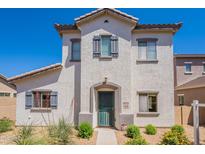 A two-story home with a white textured facade, a tile roof, and desert-style landscaping at 10324 W Sands Dr # 476, Peoria, AZ 85383