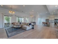 Bright and open living room with hardwood floors, a large sectional sofa, and access to the backyard at 10532 N 79Th St, Scottsdale, AZ 85258