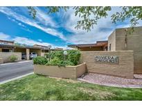Riviera Gardens community entrance with lush landscaping and covered parking, under a bright blue sky at 1146 E Rovey Ave, Phoenix, AZ 85014