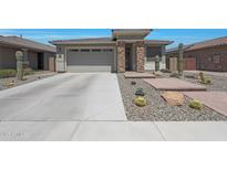 Charming single-story home featuring desert landscaping, a two-car garage, and a brick-accented entryway at 18746 W Rancho Dr, Litchfield Park, AZ 85340