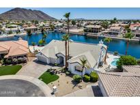 Stunning waterfront home featuring a private pool, lush landscaping, and a three-car garage at 21663 N 57Th Ave, Glendale, AZ 85308