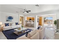 Bright living room boasts white sofas, a modern coffee table, and an open floor plan to the kitchen at 25087 W Dove Gap Dr, Buckeye, AZ 85326