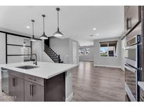 Modern kitchen with stainless steel appliances, a large island, and pendant lighting at 687 W Flintlock Way, Chandler, AZ 85286