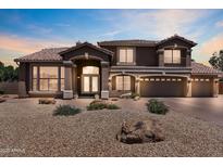 Elegant two-story home featuring a tile roof, large windows, balcony, and a three-car garage at 7524 E Leland Cir, Mesa, AZ 85207