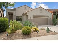 Beautiful desert landscaping complements the facade of this single-story home with a two-car garage at 7673 E Sands Dr, Scottsdale, AZ 85255