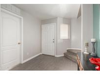 Inviting entryway with tile flooring and a white front door, leading to carpeted stairs at 11473 W Austin Thomas Dr, Surprise, AZ 85378