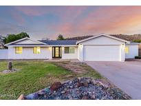 Charming single-story home with a well-manicured lawn, attached two-car garage and mountain backdrop at 1644 W Thunderbird Rd, Phoenix, AZ 85023