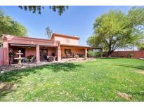 A spacious backyard with lush grass, trees, and a covered patio perfect for outdoor relaxation and entertaining at 17705 E Canyon Way, Gilbert, AZ 85298