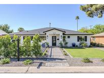 Charming single-story home with a manicured lawn, inviting walkway, and black trimmed windows at 3029 E Elm St, Phoenix, AZ 85016
