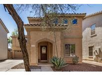 Charming two-story home featuring an arched entryway, tile roof, and desert landscaping at 514 N 112Th Dr, Avondale, AZ 85323