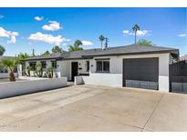 Charming single-story home featuring a well-manicured yard and a convenient attached garage at 5320 E Thomas Rd, Phoenix, AZ 85018