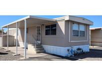 Inviting manufactured home featuring covered entry, tidy landscaping, and neutral color palette at 730 S Country Club Dr # 81, Mesa, AZ 85210