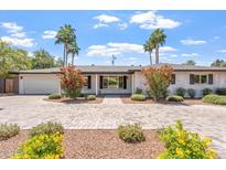 Charming single-story home with a well-manicured yard, brick driveway, and colorful shrubbery at 735 E Northern Ave, Phoenix, AZ 85020