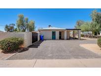 Charming exterior features a covered porch, white stucco, and a spacious driveway, perfect for parking at 1701 W Clarendon Ave, Phoenix, AZ 85015
