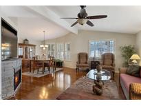 Inviting living room features hardwood floors, fireplace, and natural light from plantation shutters at 17200 W Bell Rd # 1748, Surprise, AZ 85374