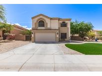 Charming two-story home with a well-maintained front yard and wide driveway leading to the attached two-car garage at 23119 W Papago St, Buckeye, AZ 85326