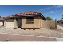Well-maintained single-story home featuring a tile roof, two-car garage, and desert landscaping with accent plants at 2358 E Peach Tree Dr, Chandler, AZ 85249