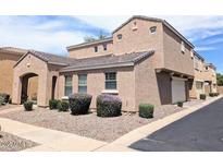 Two-story tan home featuring arched entry and well-manicured landscaping at 3020 E Megan St, Gilbert, AZ 85295