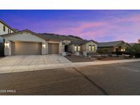 Charming single-story home featuring a three-car garage, desert landscaping, and a welcoming facade at 3551 W Hidden Mountain Ln, Anthem, AZ 85086