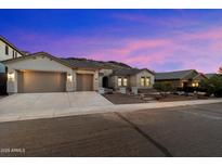 Charming single-story home with desert landscaping, three-car garage, and a tile roof at dusk at 3551 W Hidden Mountain Ln, Anthem, AZ 85086