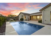 A backyard view featuring a sparkling pool with water fountains, and an outdoor kitchen at 3551 W Hidden Mountain Ln, Anthem, AZ 85086