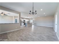 Open-concept living area with wood-look tile flooring, recessed lighting, and kitchen view at 3887 S 331St Ave, Tonopah, AZ 85354